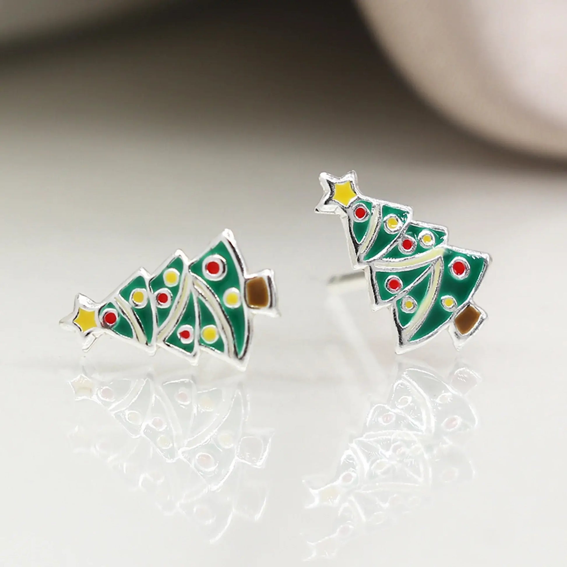 Pair of silver stud earrings shaped like Christmas trees with enamelled details