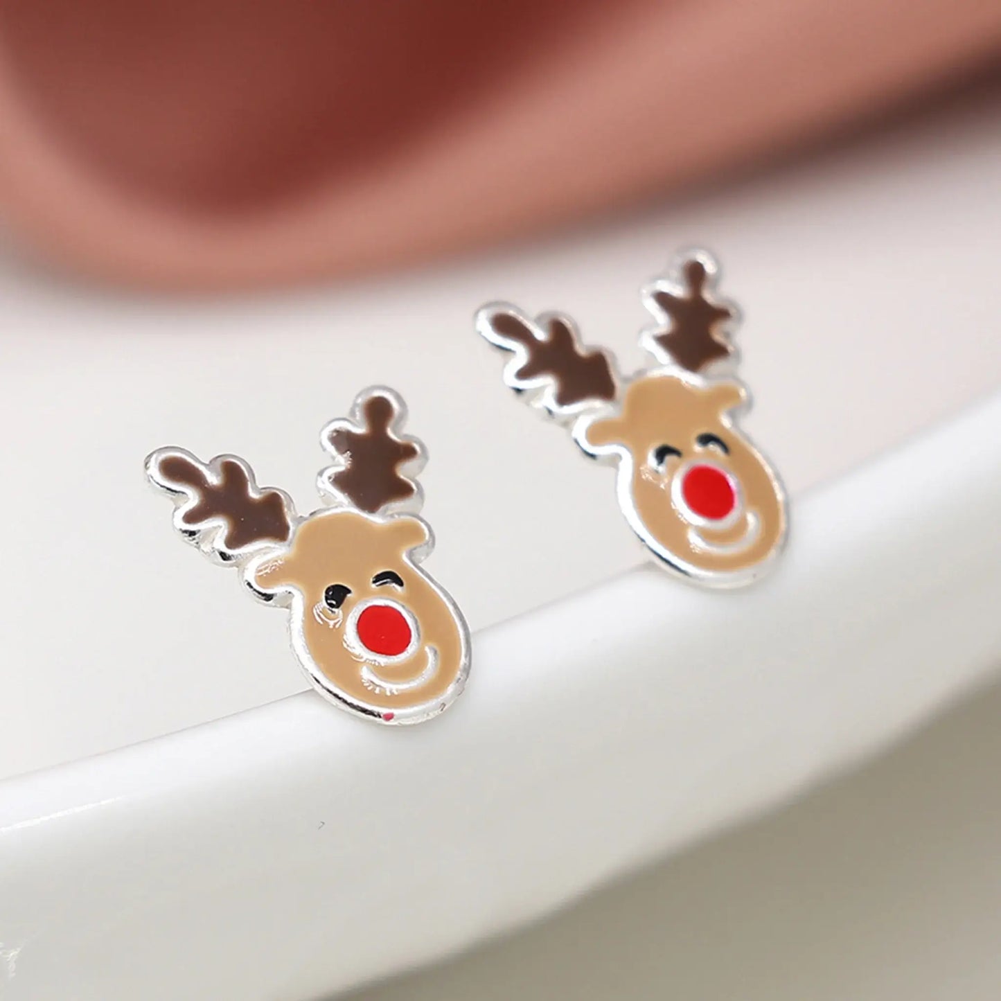Pair of silver stud earrings shaped like Rudolph the reindeer with enamelled details