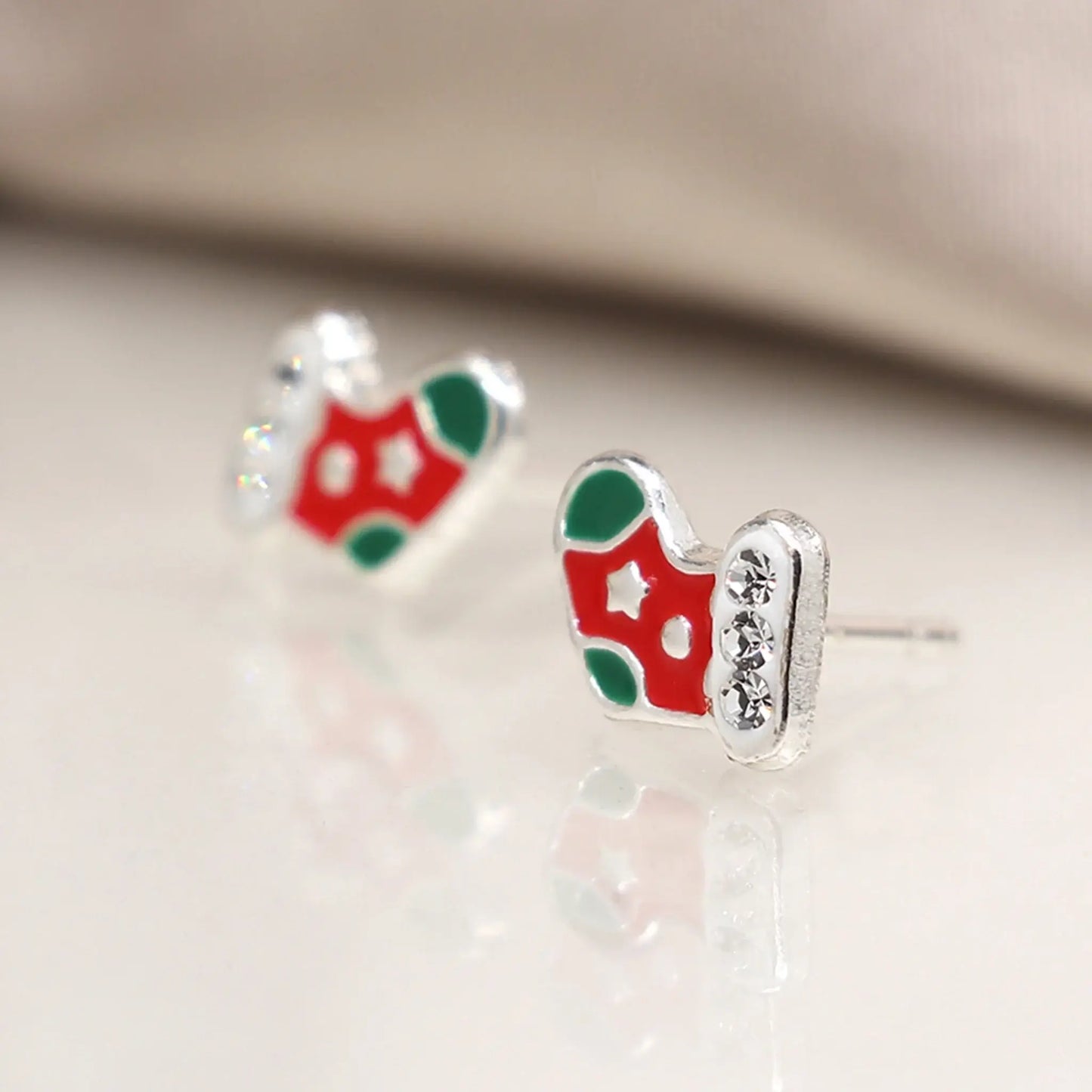 Pair of silver stud earrings shaped like stockings with enamelled details