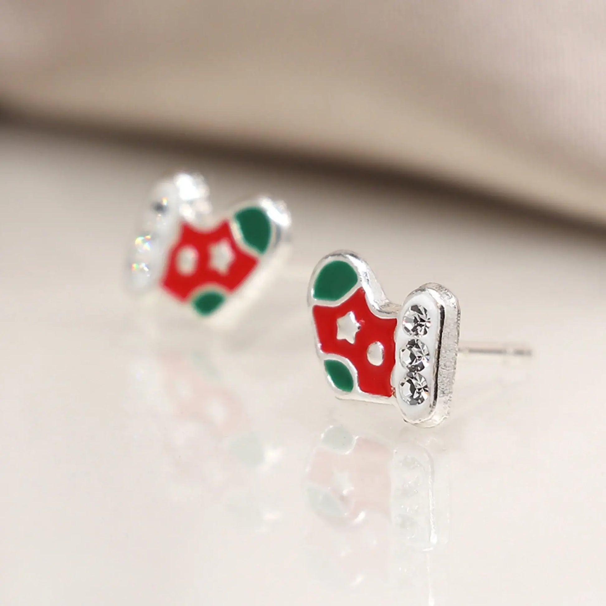 Pair of silver stud earrings shaped like stockings with enamelled details