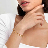 Model wearing a yellow gold Nomination bangle in a chain shape with CZ stones