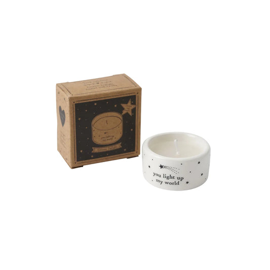A white ceramic tealight holder with a phrase and shooting star design