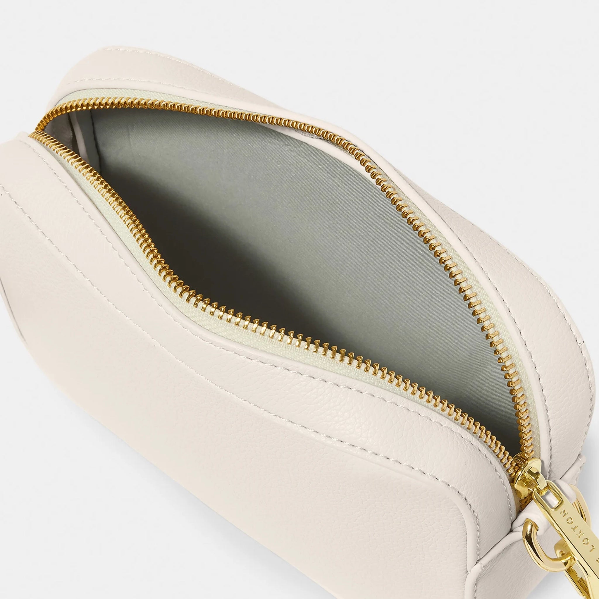 An off-white crossbody bag in a simple box shape with adjustable canvas strap and gold hardware open