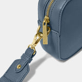 A navy blue crossbody bag in a simple box shape with adjustable canvas strap and gold hardware detail