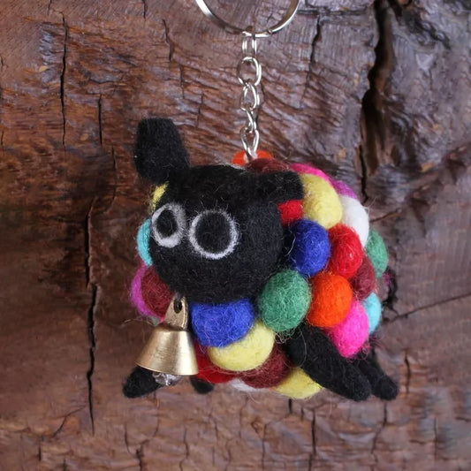 A felted sheep keychain with rainbow pompom and a brass bell