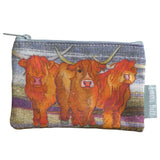A zip purse with a printed illustration of Highland cows on a felted style landscape