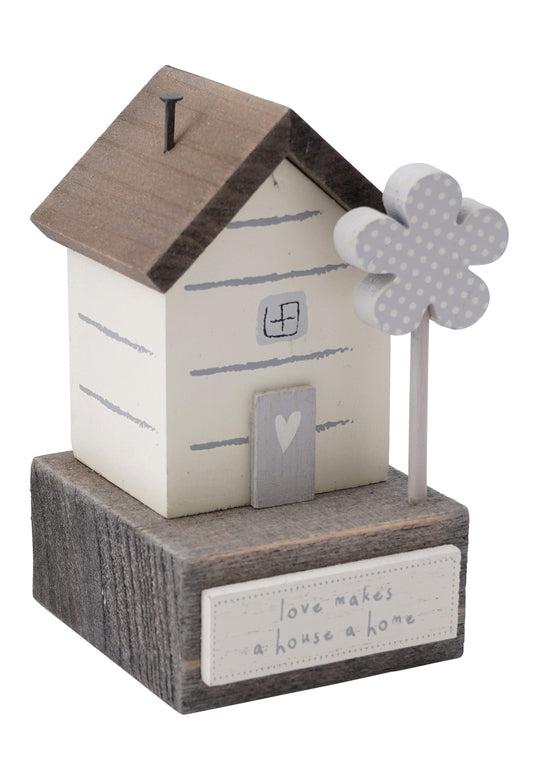 Small wooden cottage ornament in white and wood with a plaque reading 'Love Makes a House a Home''