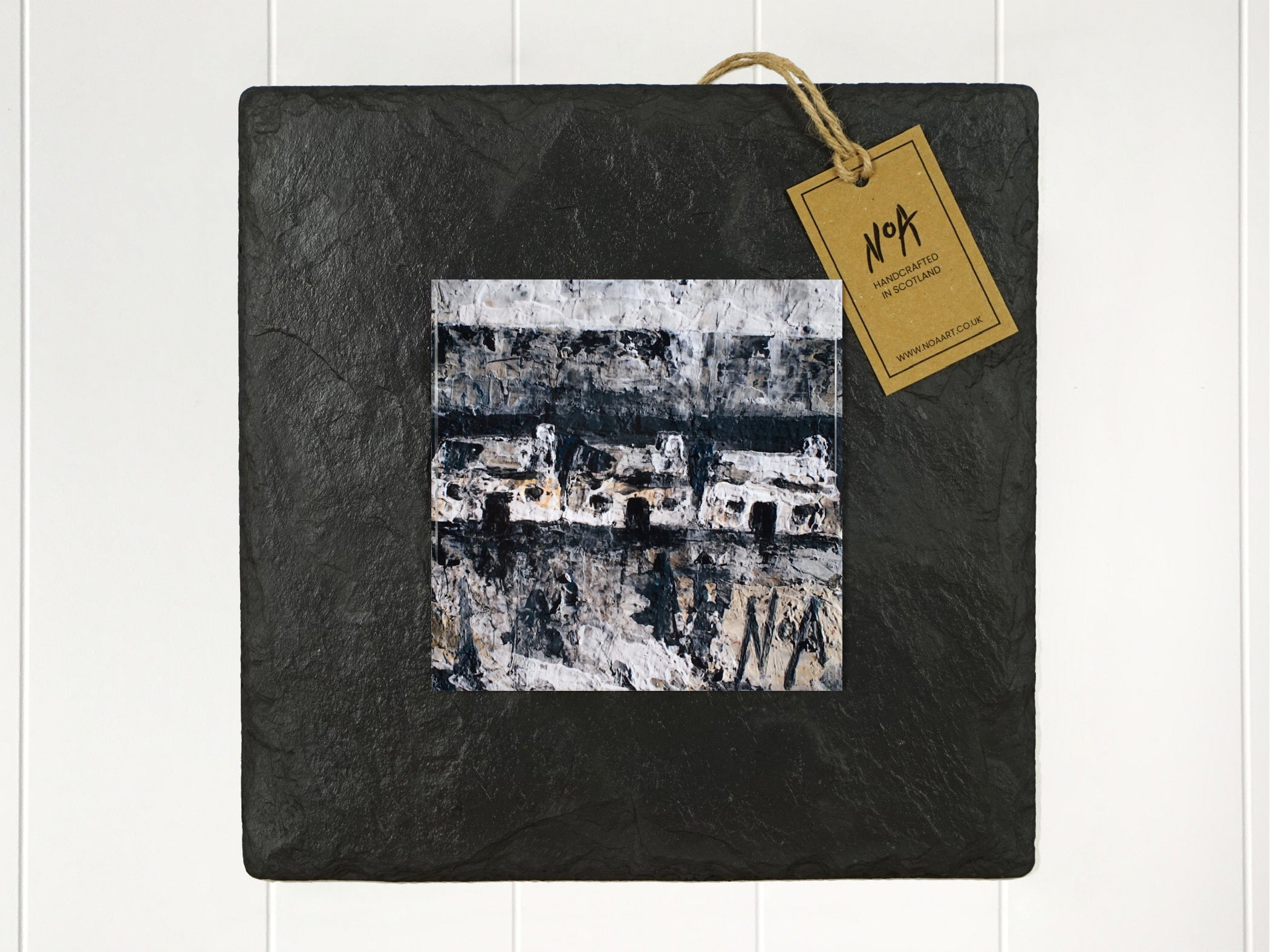  Wall art of three small white cottages in natural and grey done in an abstract style onto a square ceramic tile mounted on square slate